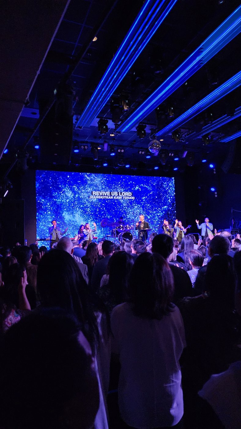 Worship night, congregation singing Revive Us Lord