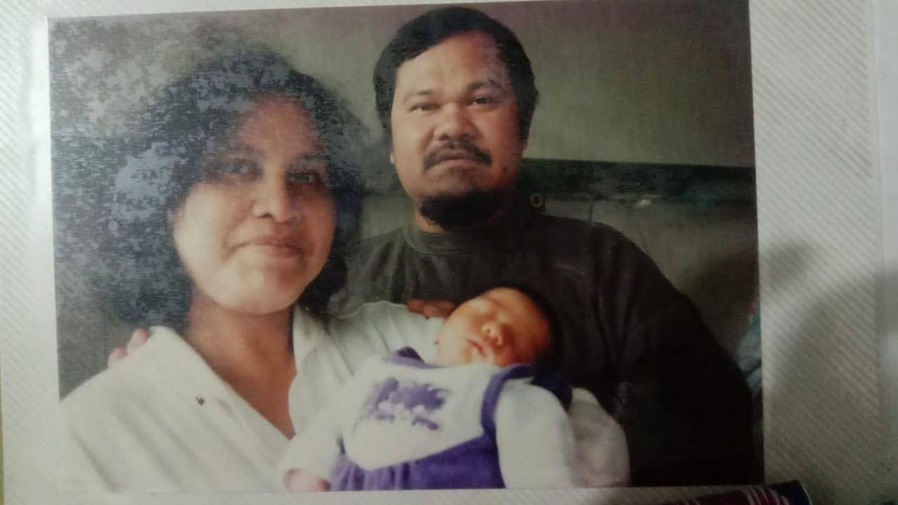 My mother and father holding me as a newborn