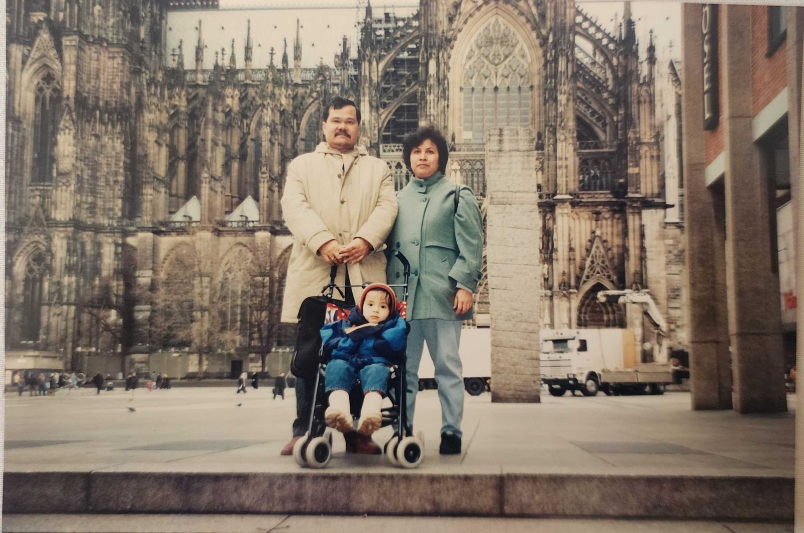 My parents standing either side of me in a pushchair on the square in front of Cologne Cathedral