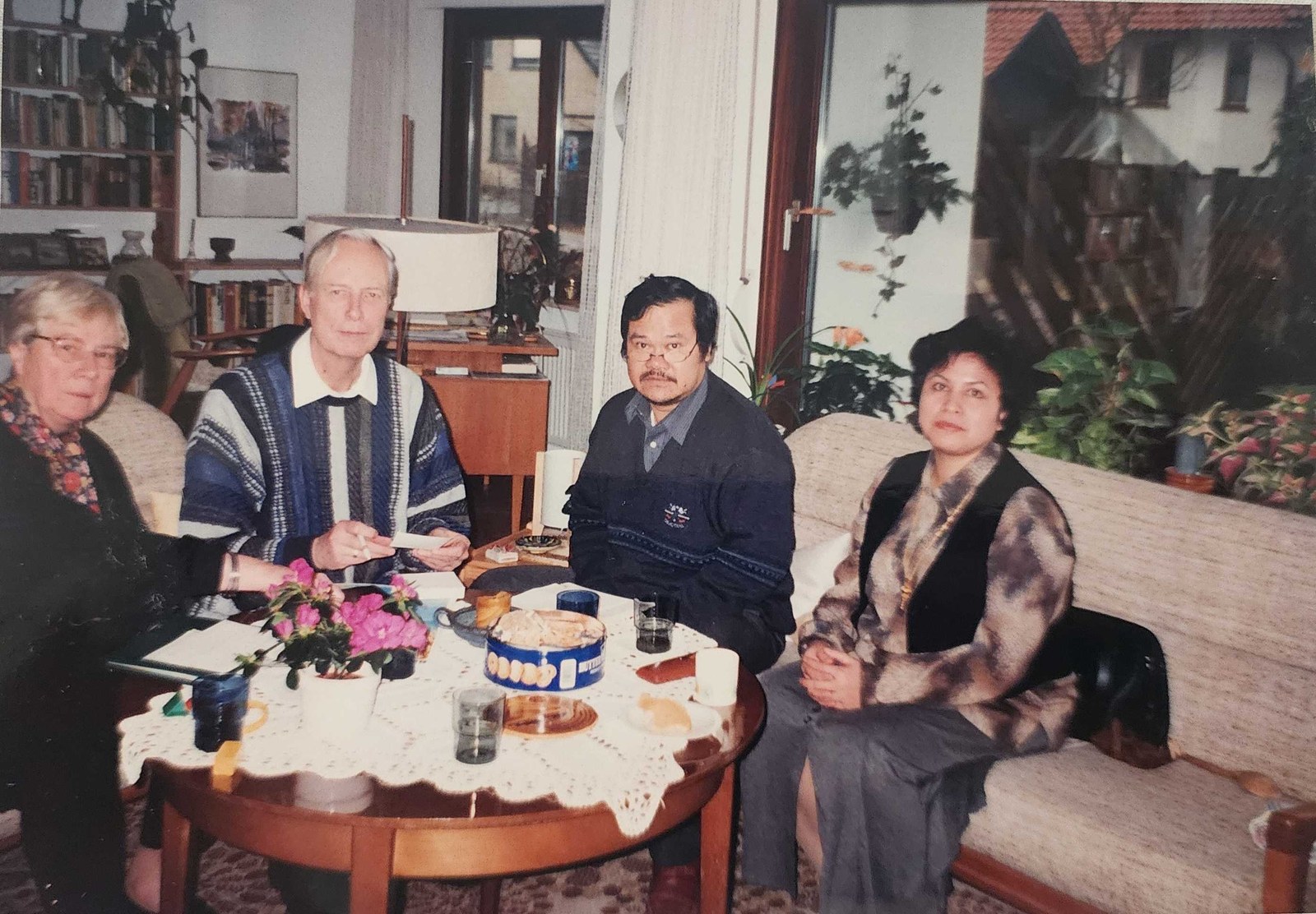 My parents sitting with a German couple around a coffee table in their living room