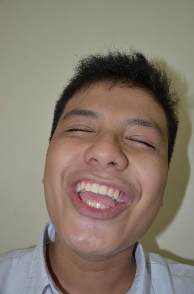 A close-up of me laughing straight into the camera, eyes shut