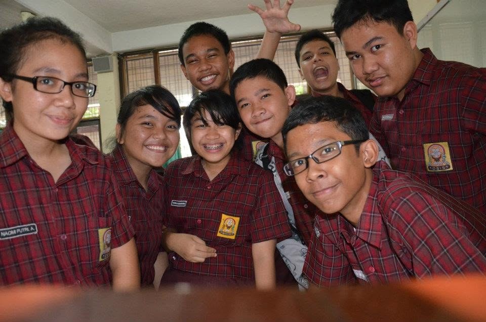 Eight of us leaning into the camera over a desk