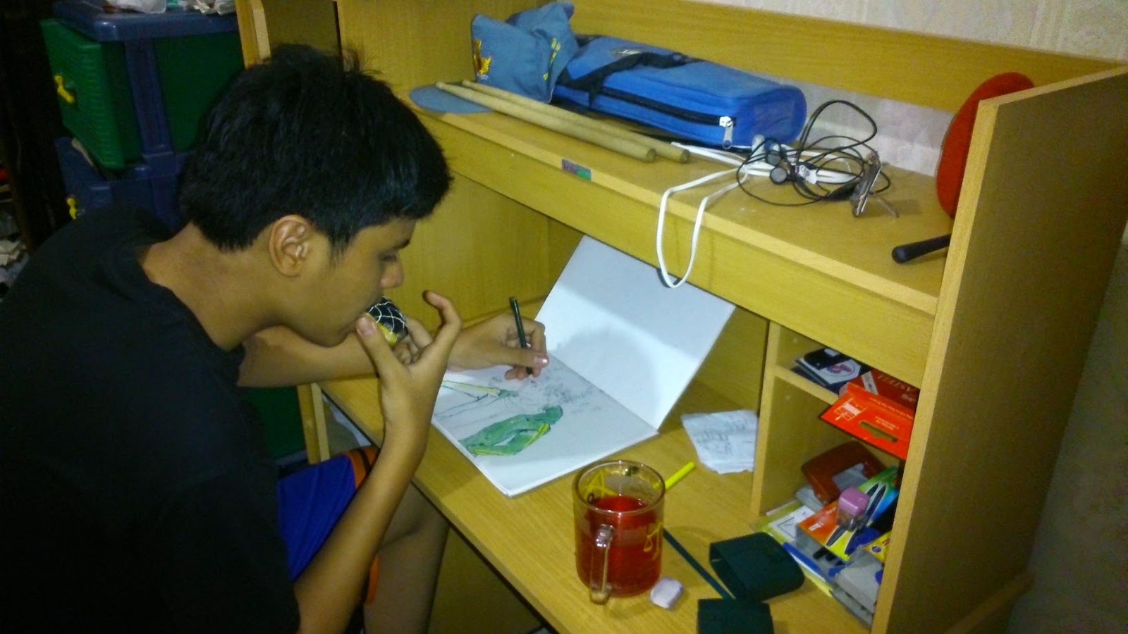 Sketching in a notebook at a study desk at home