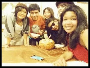Friends around a table with a carved pumpkin