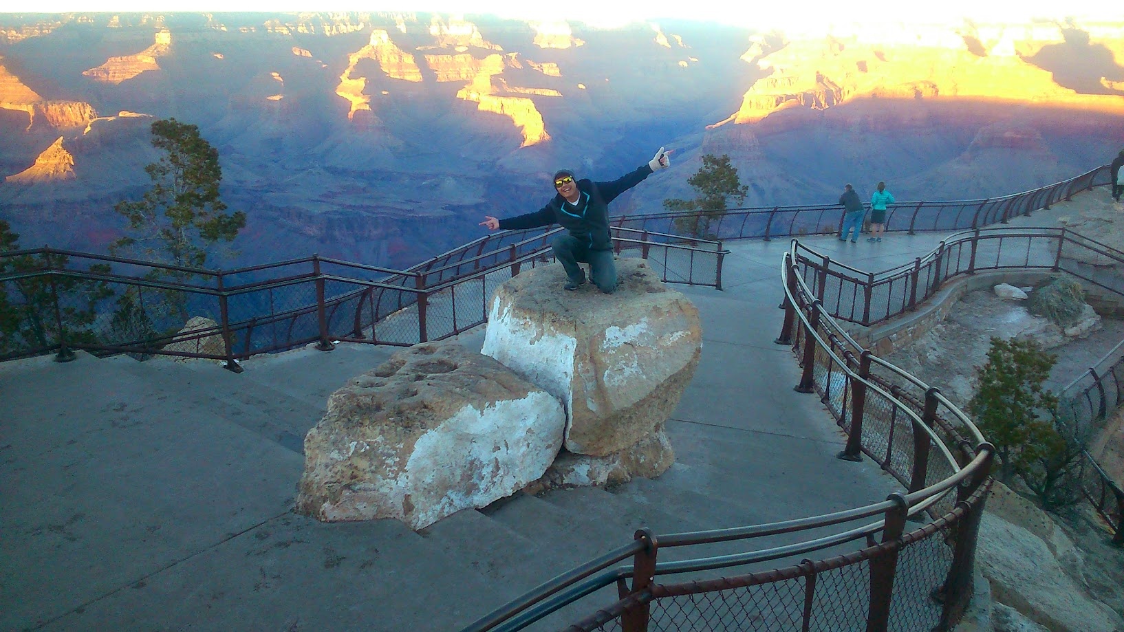 Standing on a rock at the Grand Canyon rim at sunrise