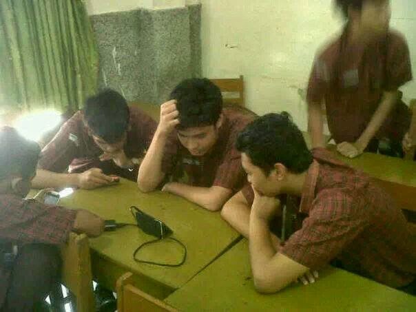 Three of us hunched over a phone at the school desks