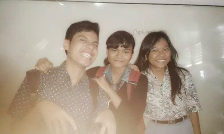 Three friends in school uniform, arms around each other
