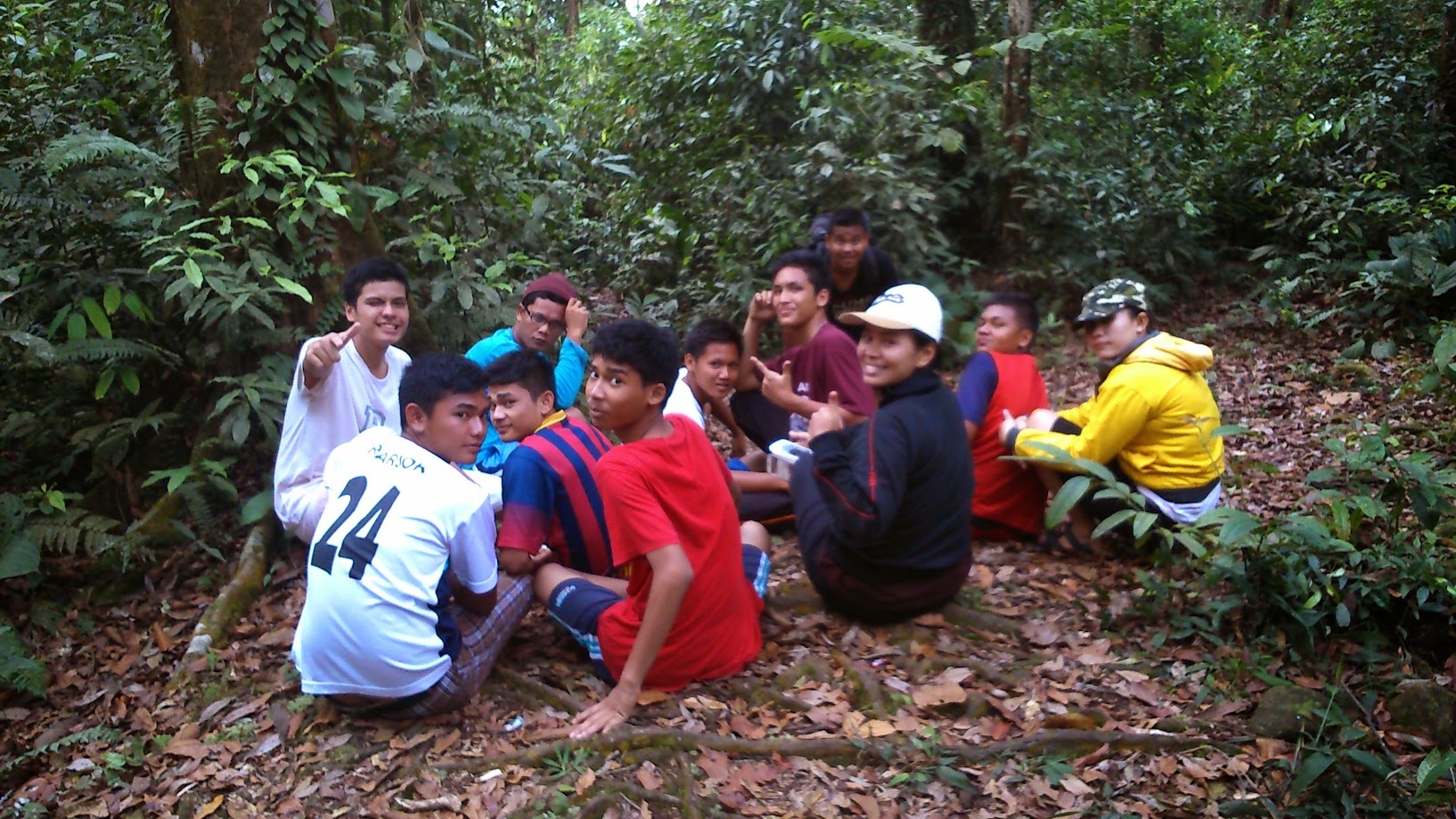 The group sitting on the forest floor partway through a hike