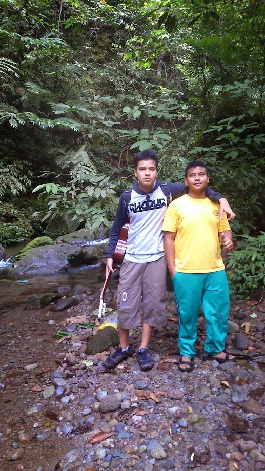 Two of us by a jungle stream, one carrying a guitar