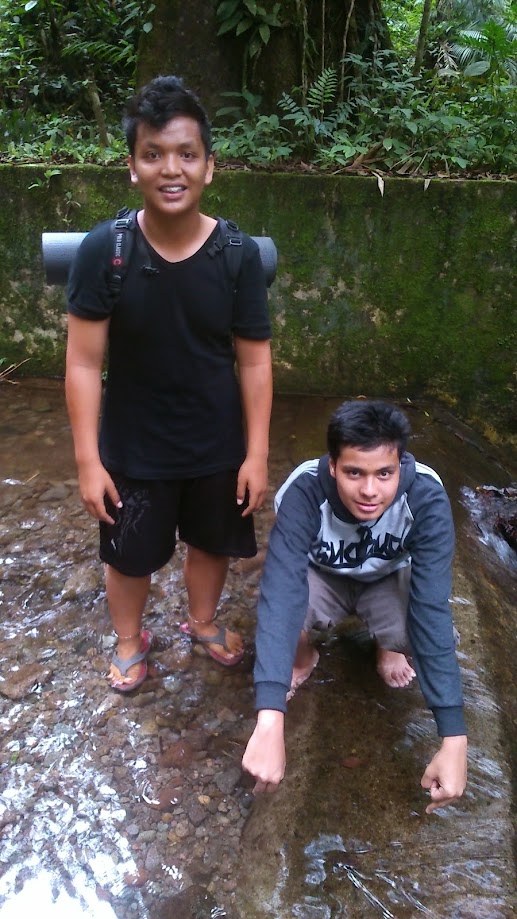 Crouching in the shallow water of a stream in the forest
