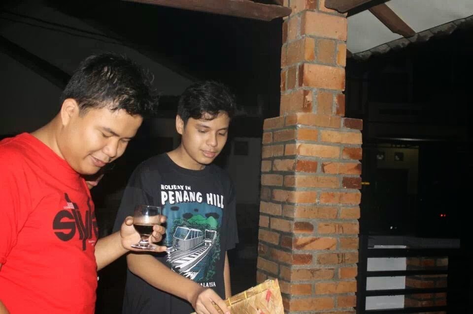 Two of us outside at night, one holding a glass of coffee