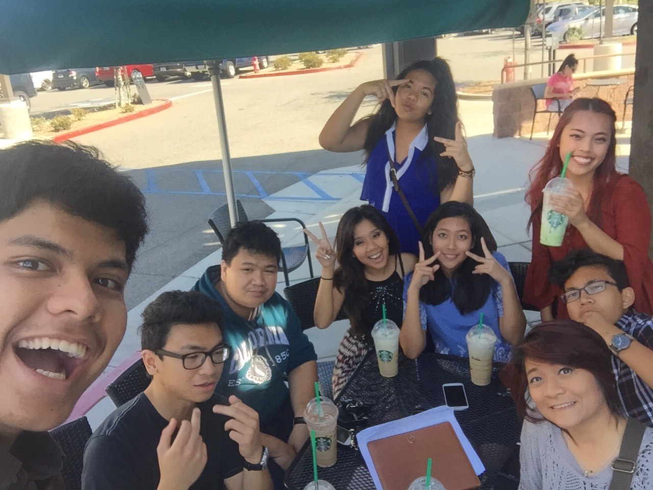 Sitting outside a Starbucks with a group of friends, everyone crowded into one selfie