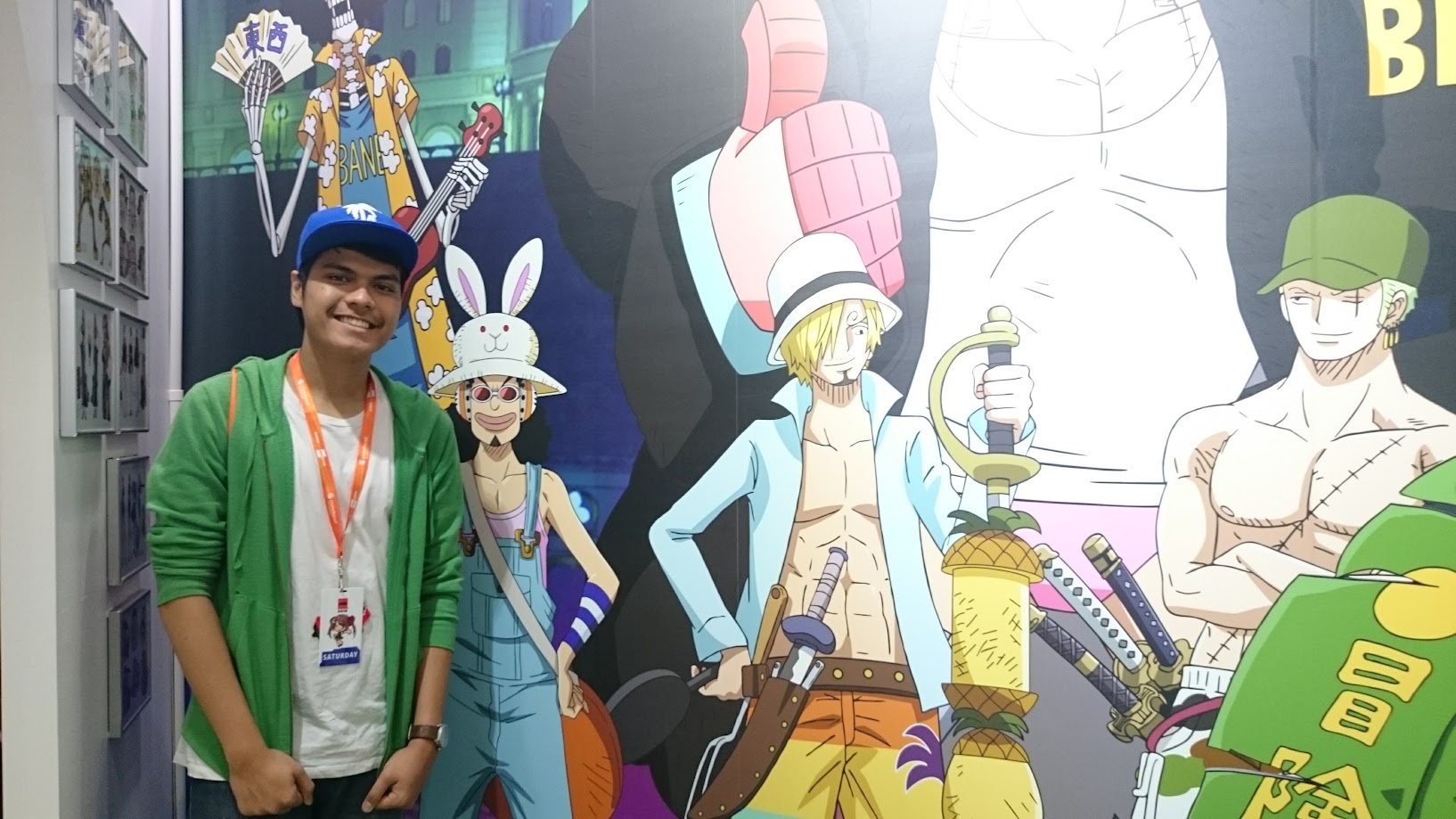 Standing beside a One Piece backdrop at an anime convention