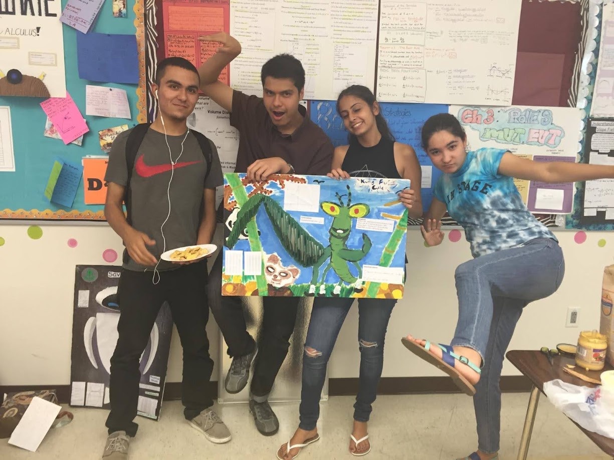 Holding up a hand painted Kung Fu Calculus project poster in the classroom with classmates
