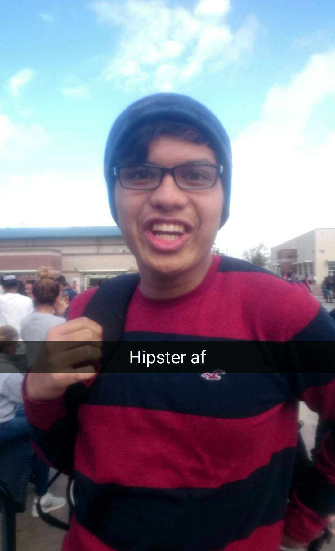 A snap outside school in a beanie and a striped sweater, captioned Hipster af