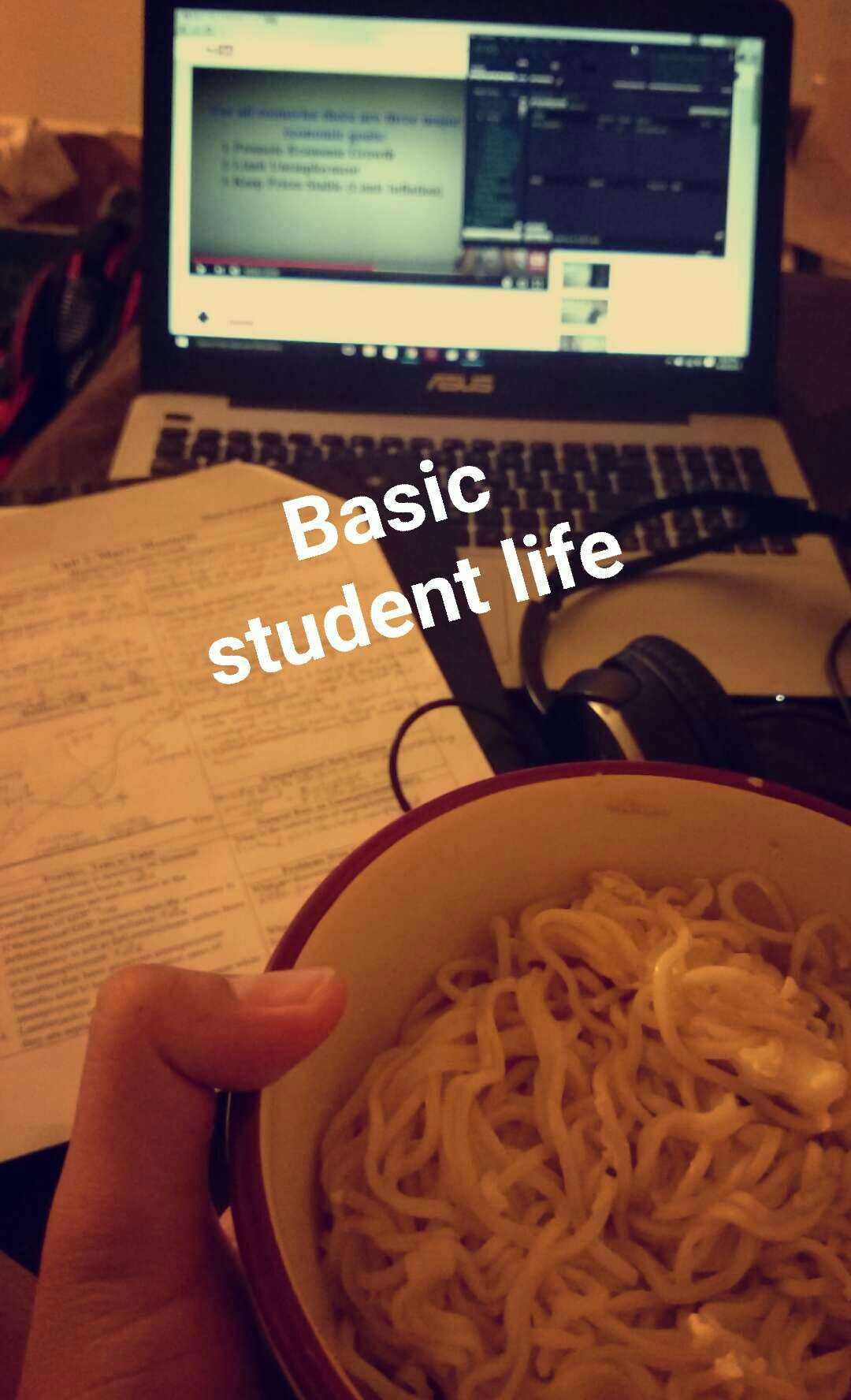 Macroeconomics slides on the laptop, notes spread out and a bowl of noodles