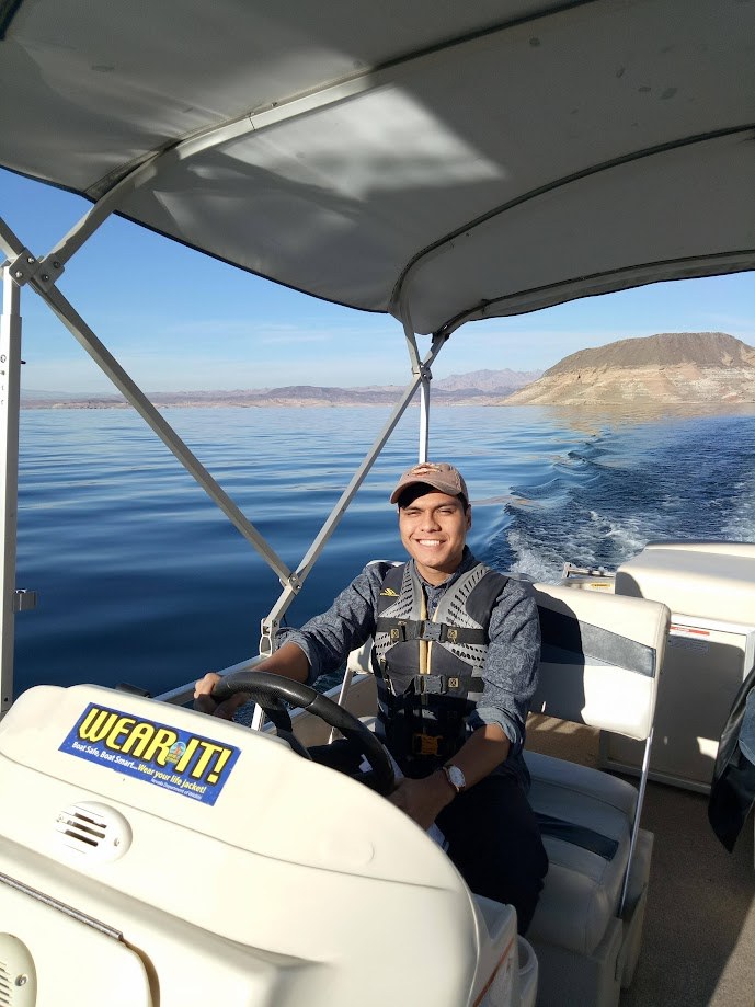 Driving a pontoon boat across a lake on a clear day