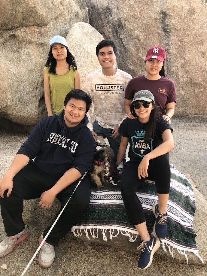 Five of us posed on a blanket against the boulders in the desert, with a dog in the middle