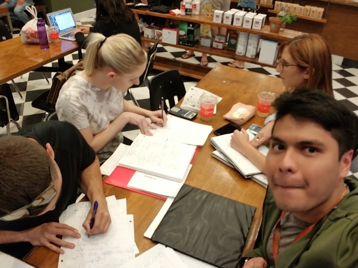Study group with notebooks and a calculator at a tea shop