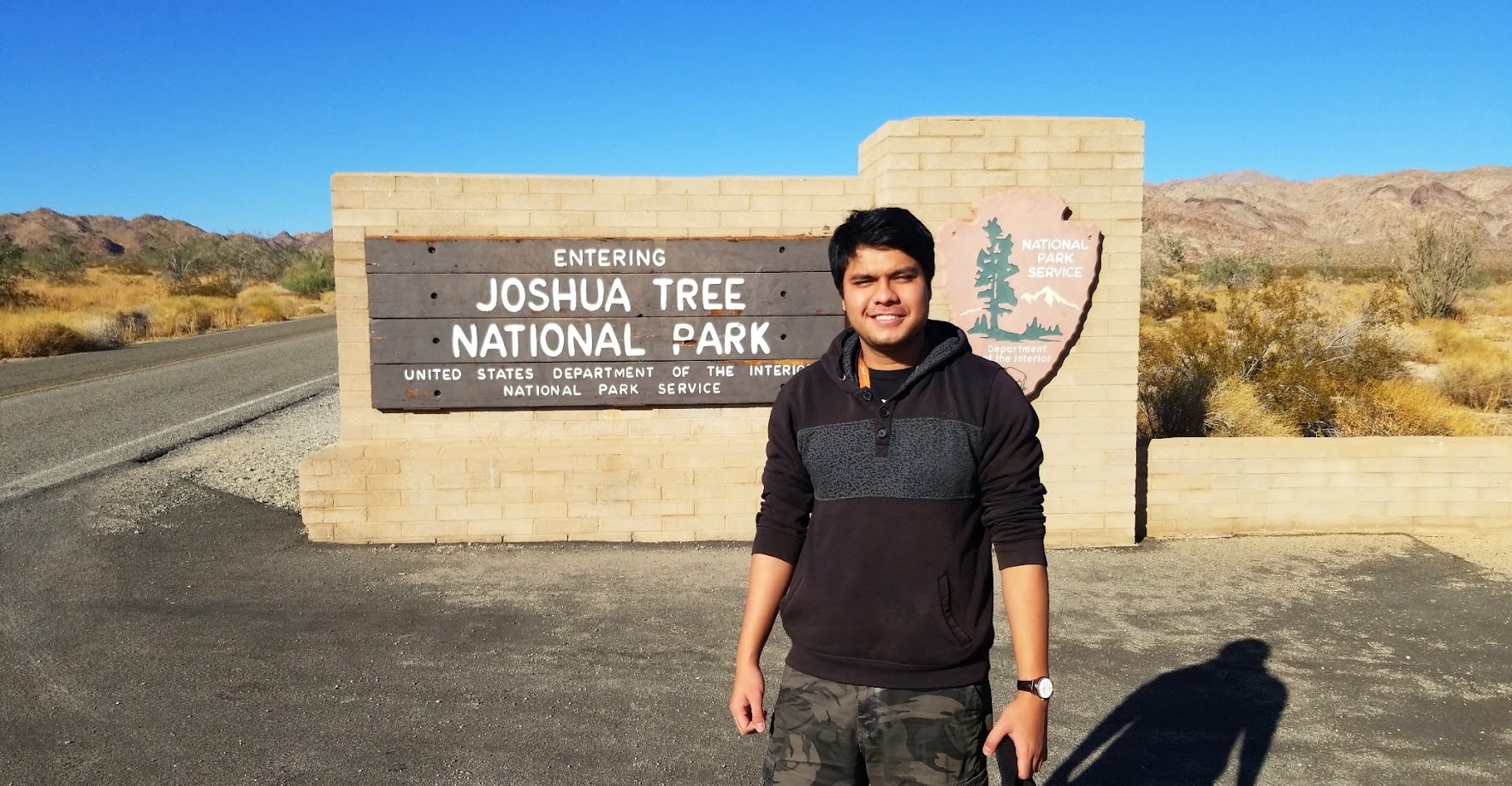 Standing at the Joshua Tree National Park entrance sign