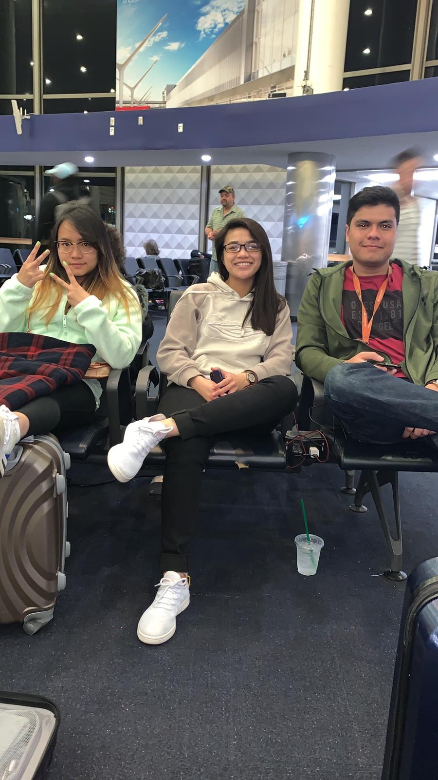 Three of us sitting with our luggage in an airport departure lounge