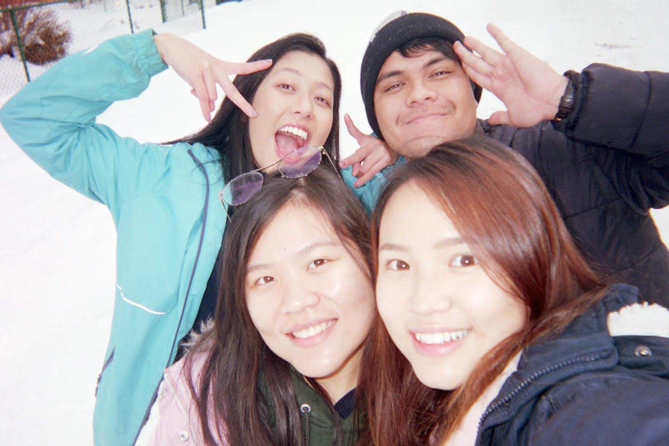 Four of us crowded into a selfie in the snow, everyone throwing peace signs