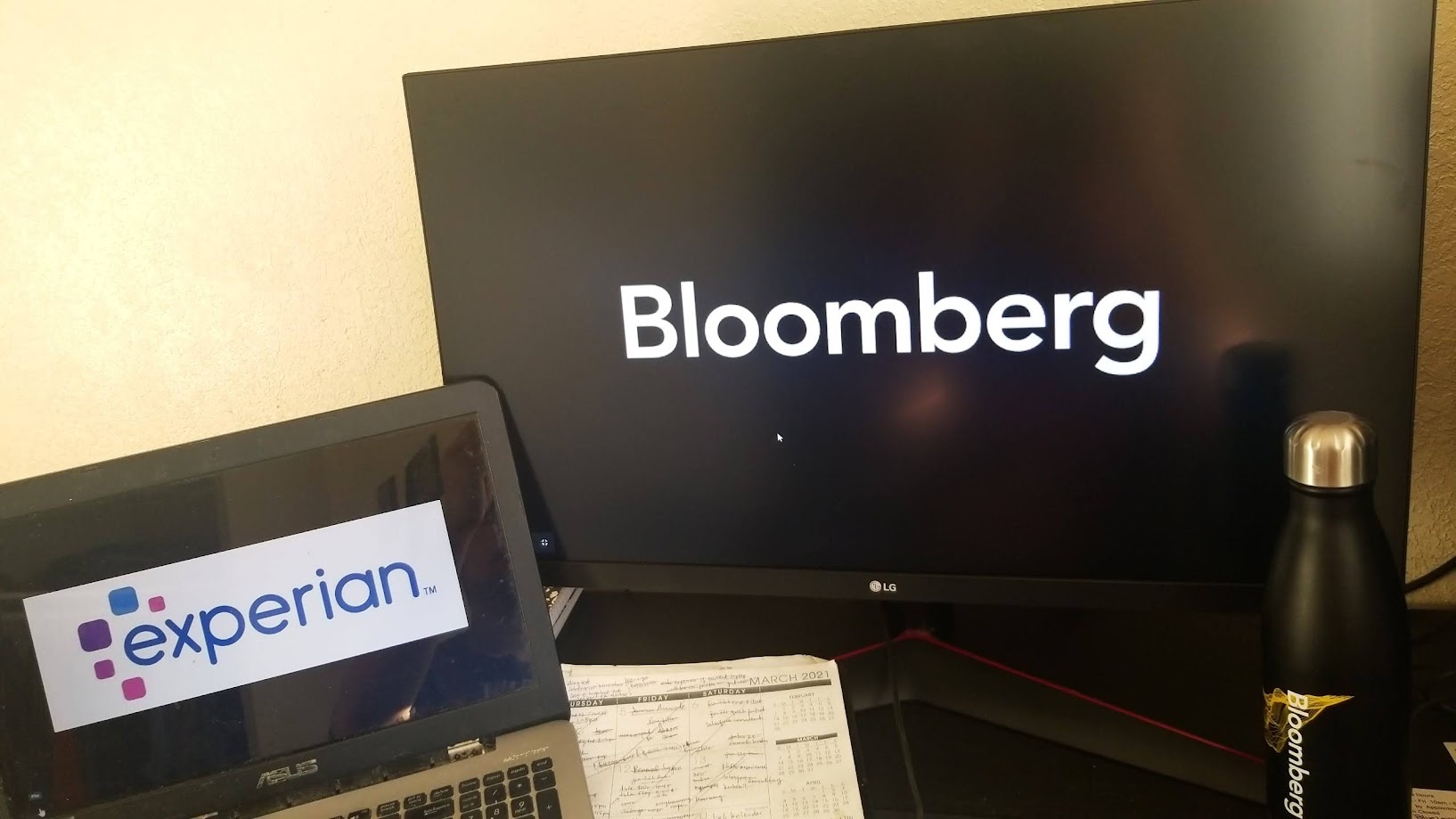 Bloomberg loading on the monitor and Experian on the laptop beside it