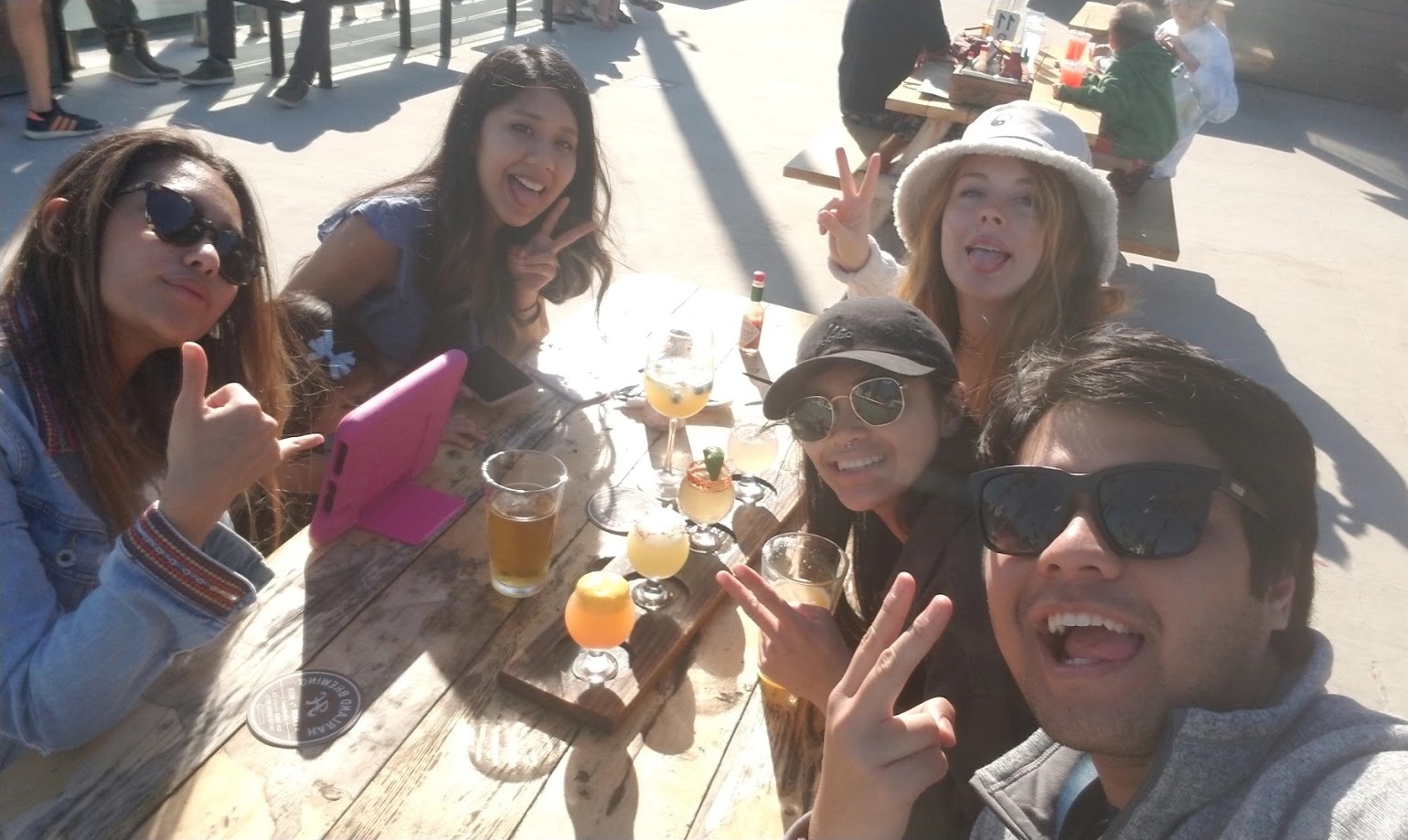 Five of us crowded into a selfie around a brewery picnic table