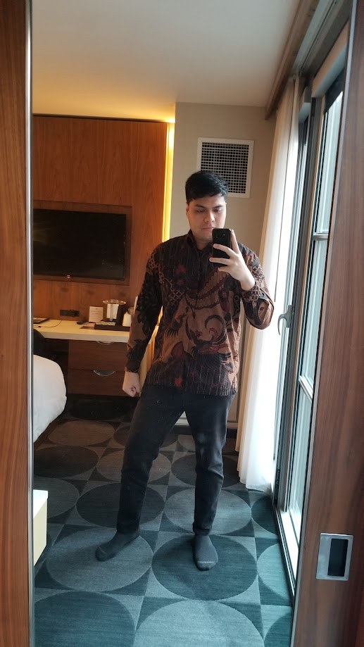 Mirror selfie in a batik shirt in a hotel room