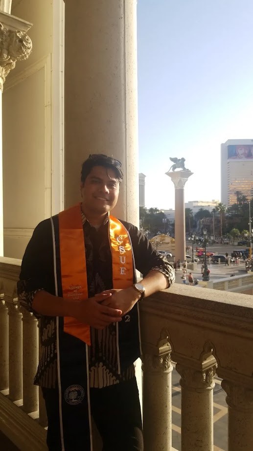 Wearing the Cal State Fullerton graduation stole on a balcony at the Venetian