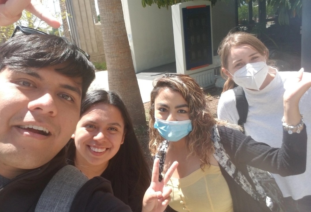 Selfie with three friends walking across campus, still masked