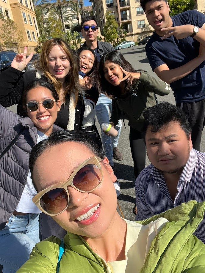 Group selfie in the apartment parking lot on a bright day
