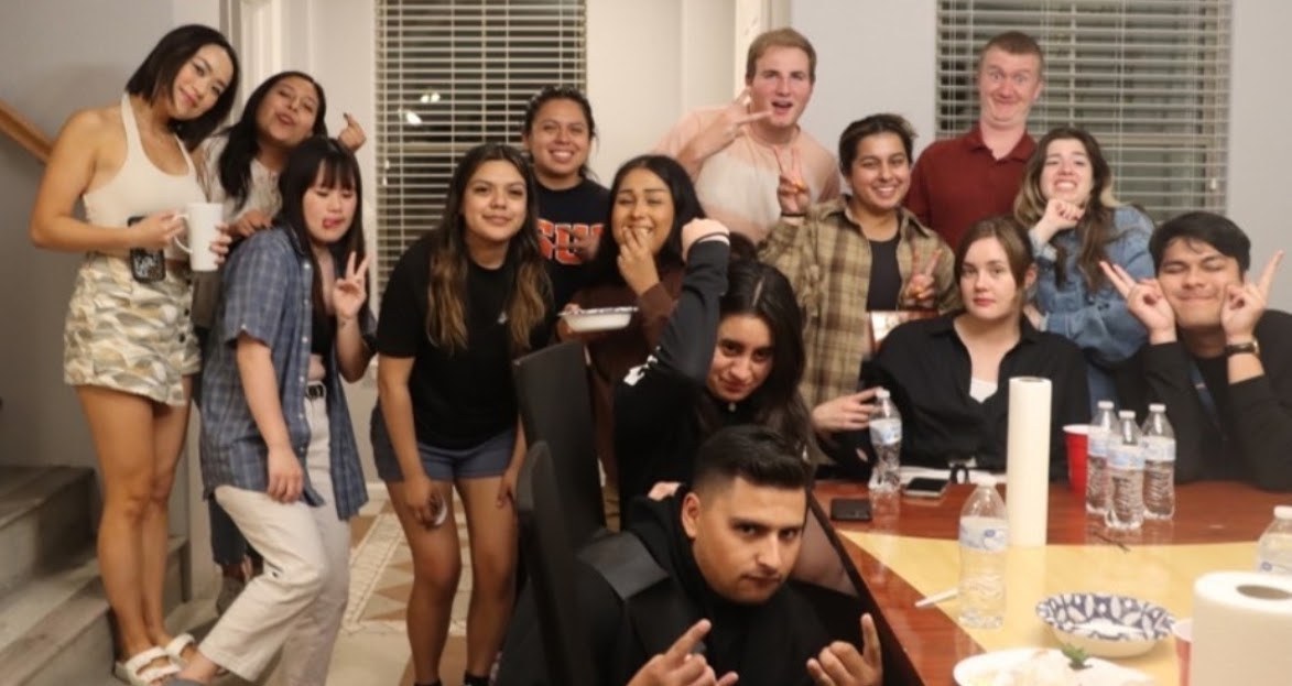 Friends crowded into a kitchen for a house party photo