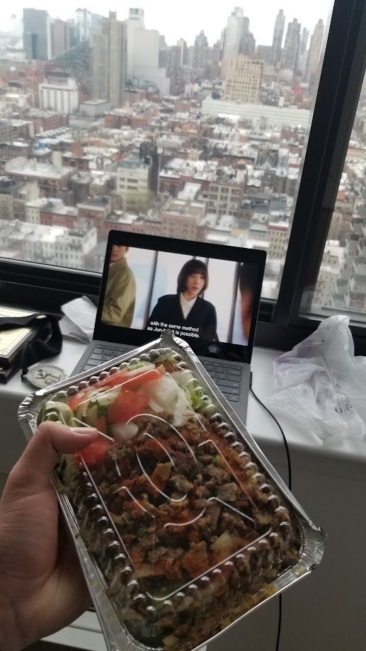 Halal cart dinner on the windowsill with a K-drama playing on the laptop