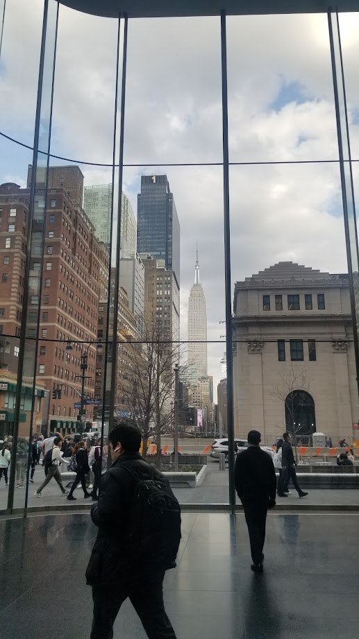 The Empire State Building framed by the glass wall of the train hall