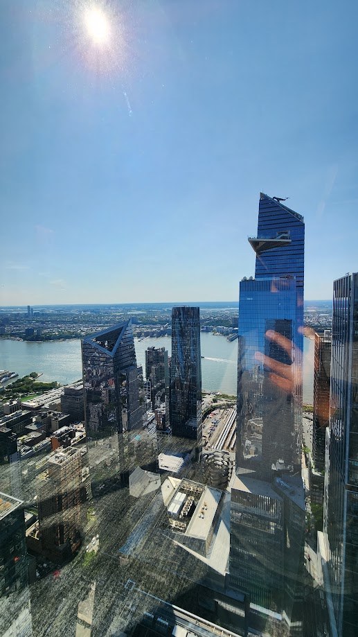 Hudson Yards and the river seen through the office glass on a bright morning