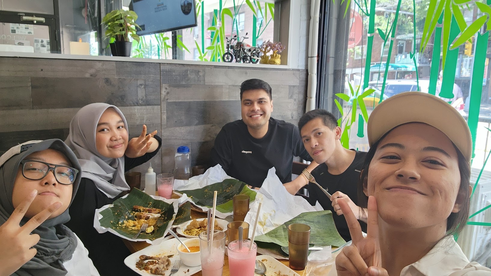 Indonesian food served on banana leaf with friends around the table