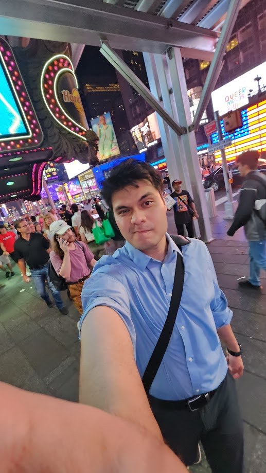 Selfie in Times Square at night with the billboards behind