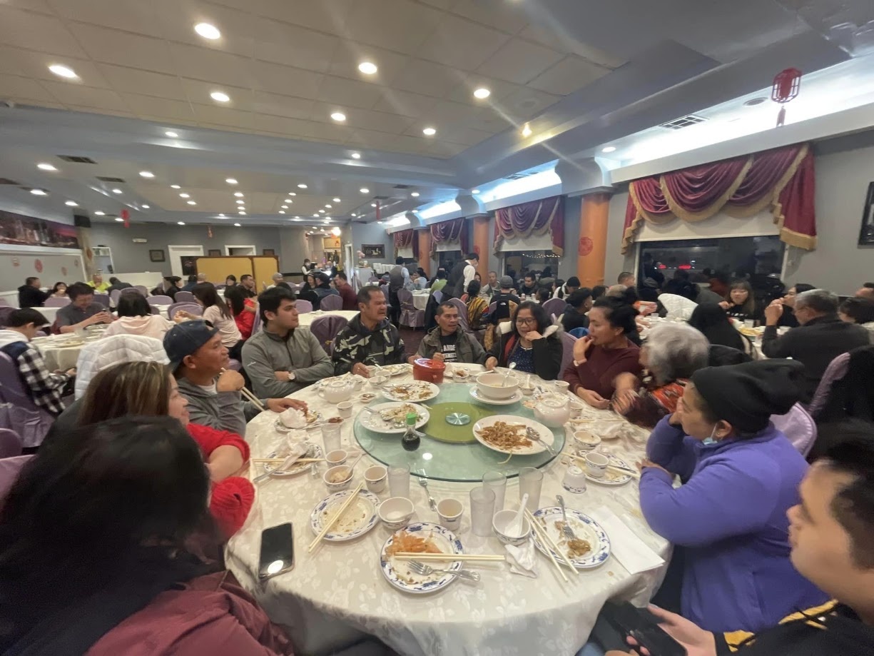 A packed banquet hall with round tables and a full spread