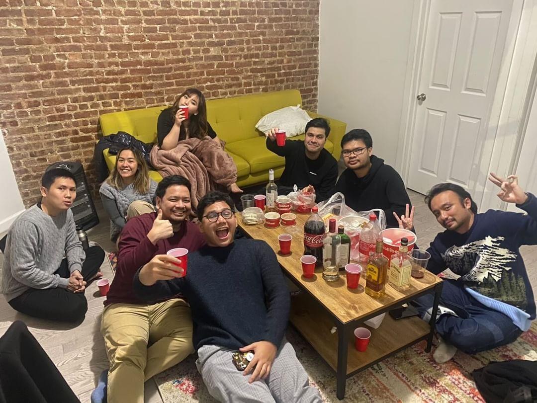 Friends around a low table in a brick walled apartment