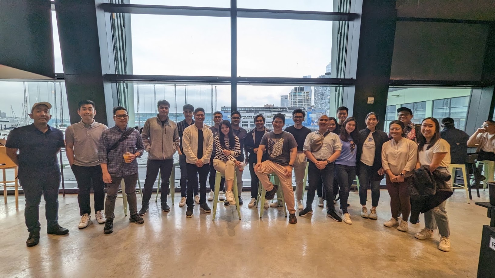 Large group at a waterfront venue in front of the tall windows