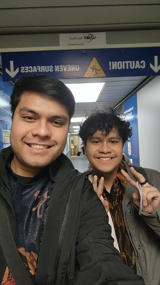Selfie with a friend on the jetway under a caution sign, just off the plane