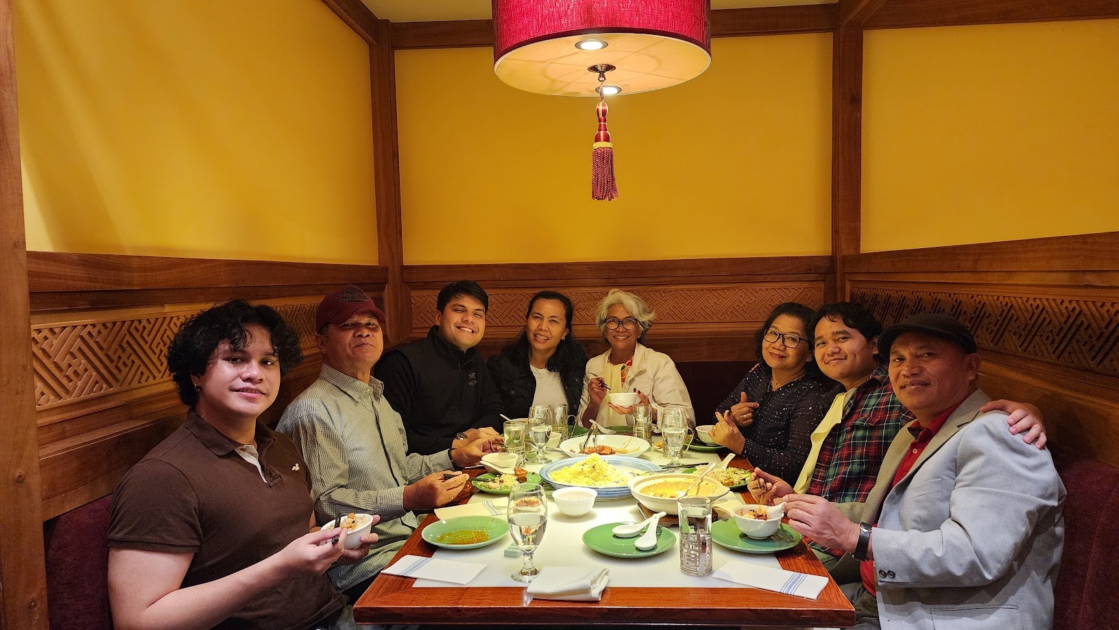 Everyone turned to the camera around the dinner table, food served