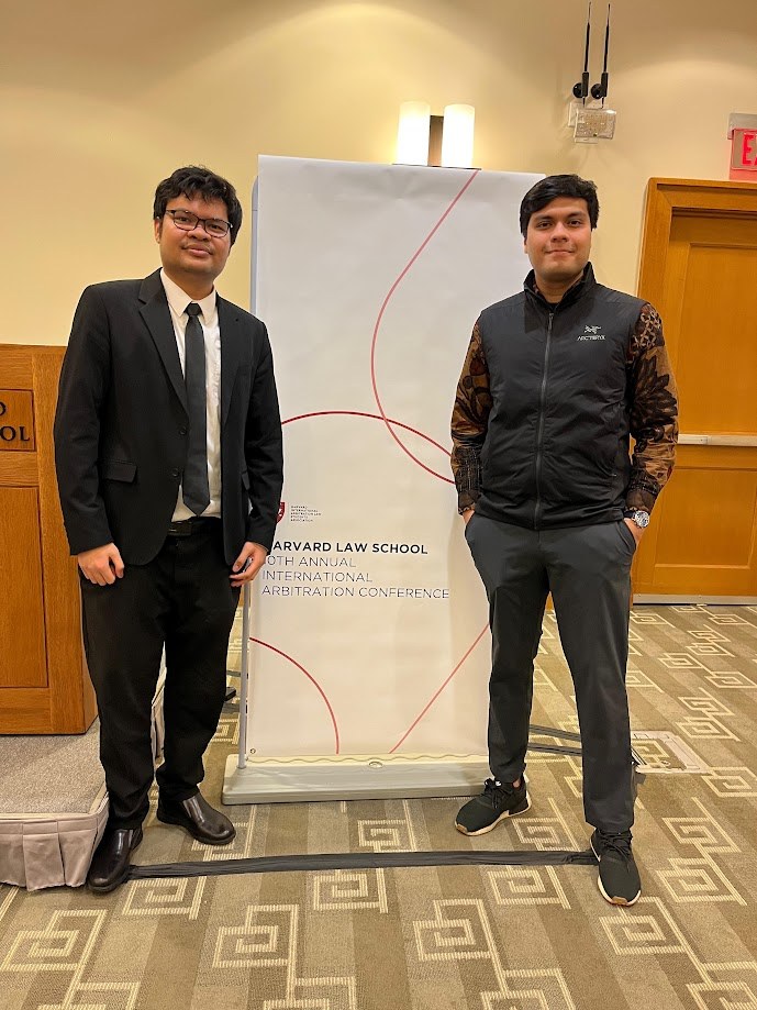 Beside the banner for the Harvard Law School annual international arbitration conference