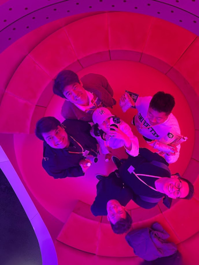 Looking up from the middle of a circular pink lit room