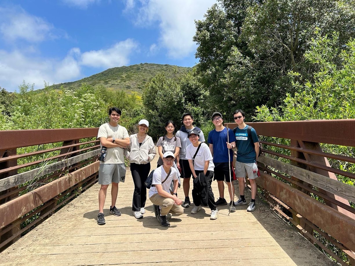 The hiking group on a wooden bridge with the ridge behind