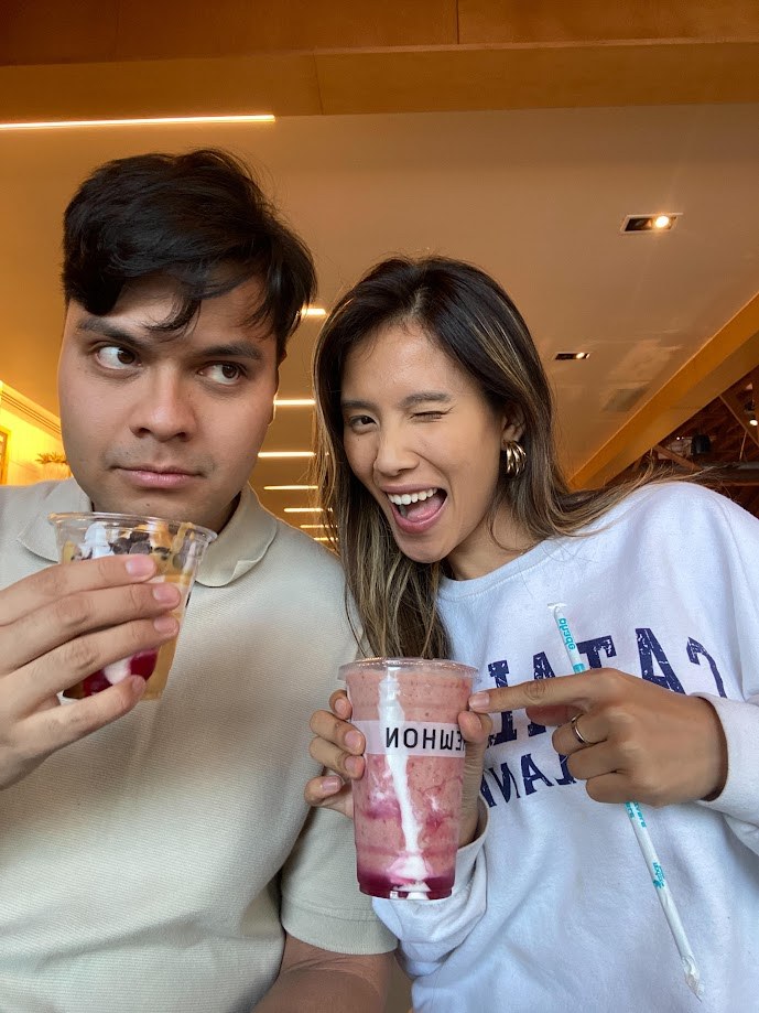 Two of us holding smoothies, mid wink
