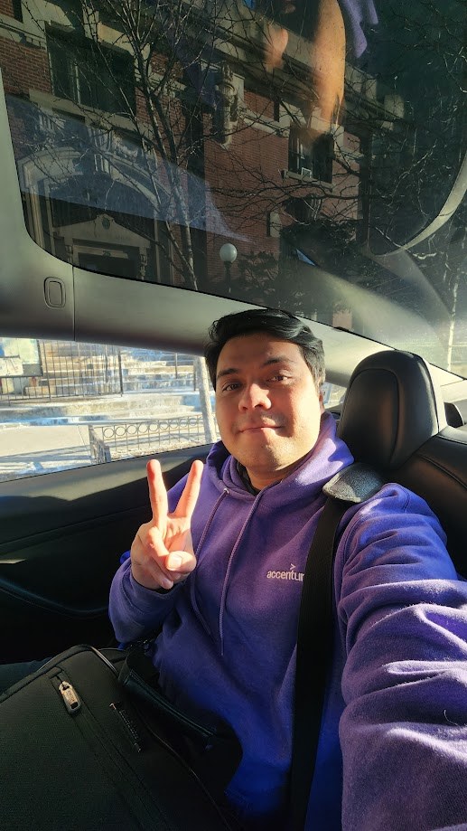 Selfie in the back of a car in an Accenture hoodie with a suitcase beside me