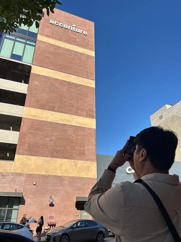 Taking a photo up at the Accenture sign on the side of the brick building