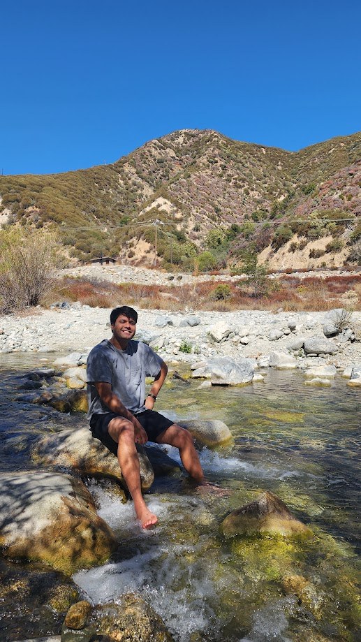 Sitting on the rocks in a creek with the hills behind